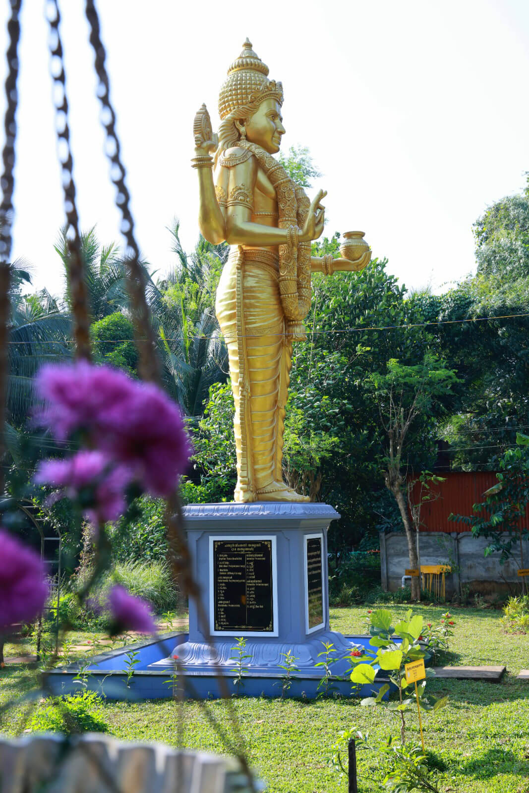 Lord Dhanwanthari statue — garden setting